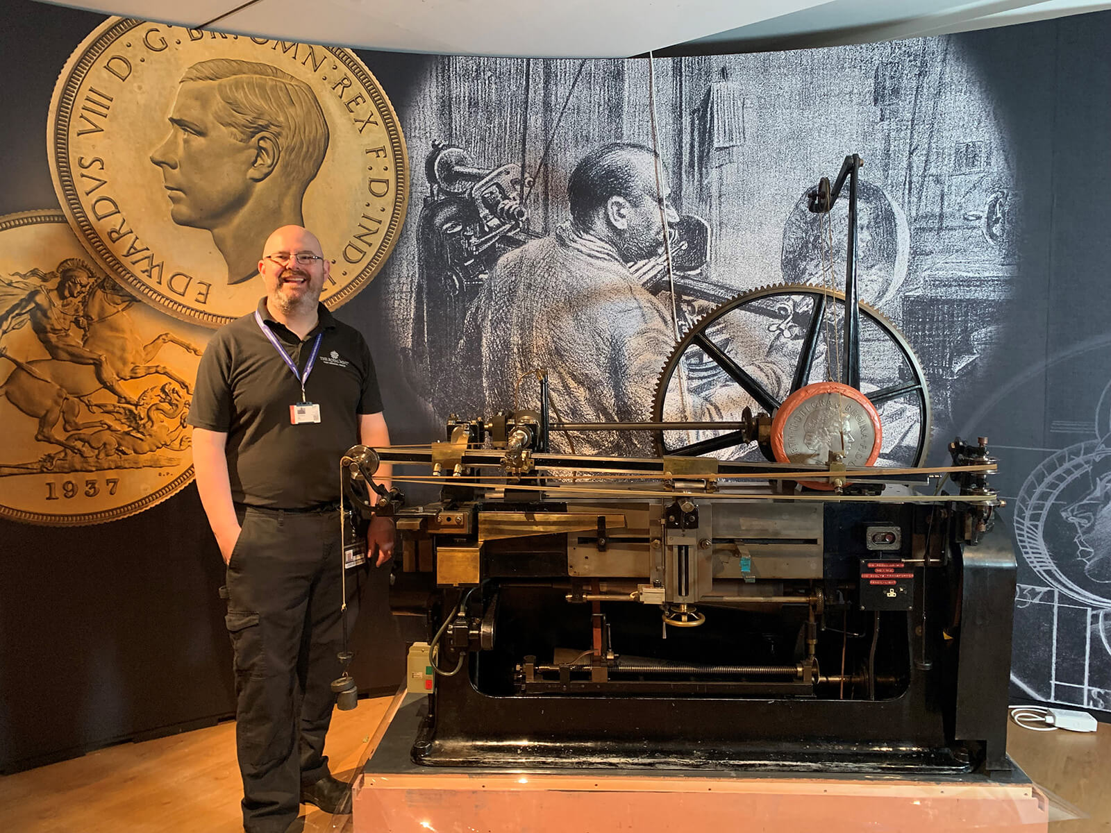 A Royal Mint worker stands next to a reducing machine in an exhibition at the Ashmolean Museum